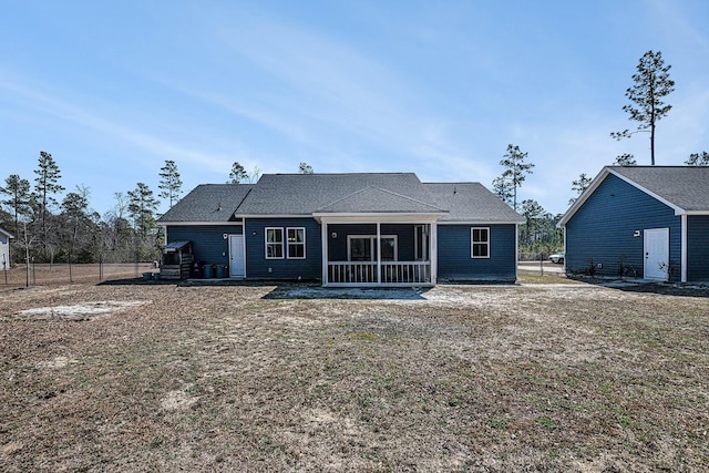 rear view of house with a sunroom and fence