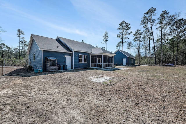 back of property featuring a sunroom and fence