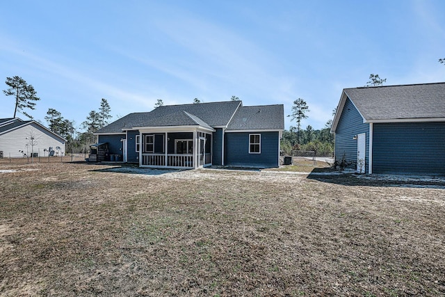 rear view of property featuring a sunroom, fence, and a yard