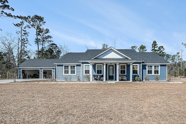 view of front of house featuring a shingled roof, a front yard, covered porch, and an attached garage