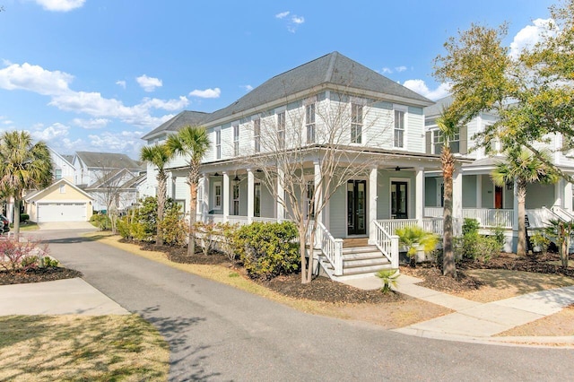 view of front of home with covered porch, an outdoor structure, and a detached garage
