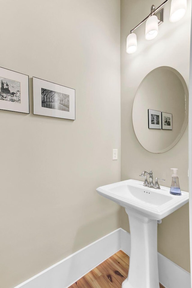 bathroom with baseboards and wood finished floors