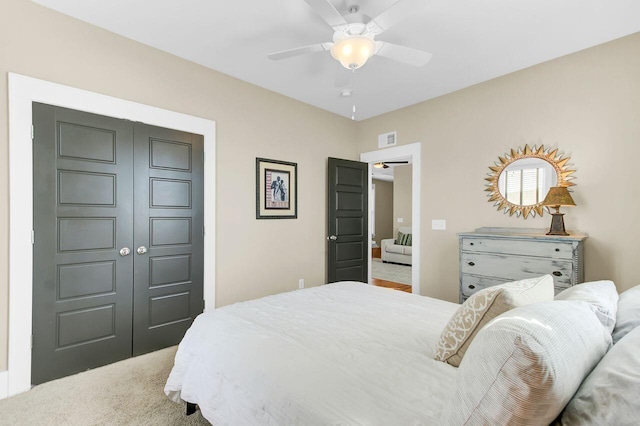 carpeted bedroom featuring visible vents, a closet, and ceiling fan