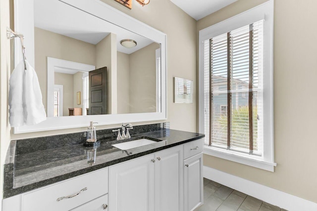 bathroom with tile patterned floors, vanity, and baseboards