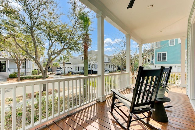 wooden deck with a residential view and a ceiling fan