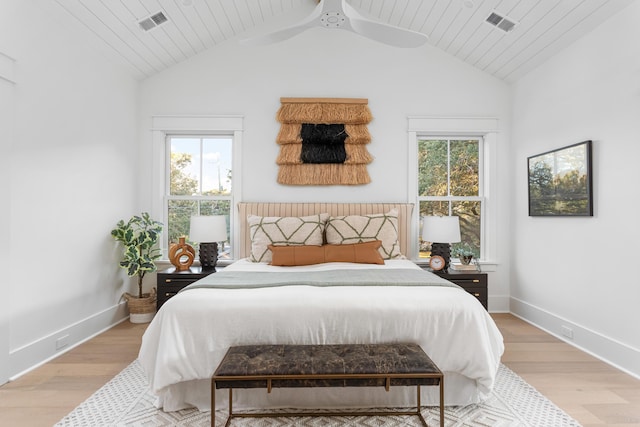 bedroom featuring multiple windows, light hardwood / wood-style flooring, and lofted ceiling