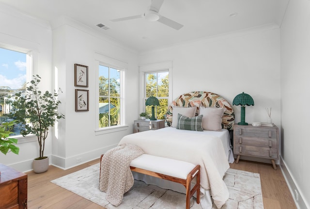 bedroom featuring crown molding, ceiling fan, and light hardwood / wood-style flooring