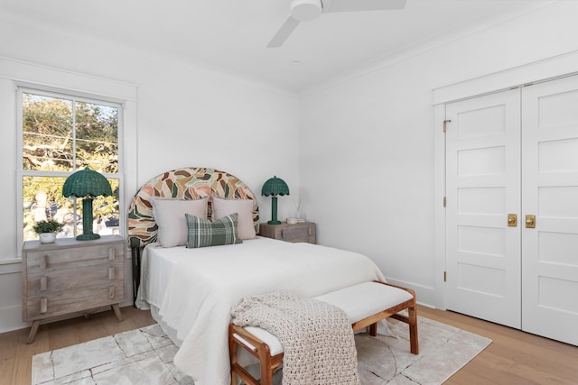 bedroom with crown molding, ceiling fan, and light hardwood / wood-style flooring