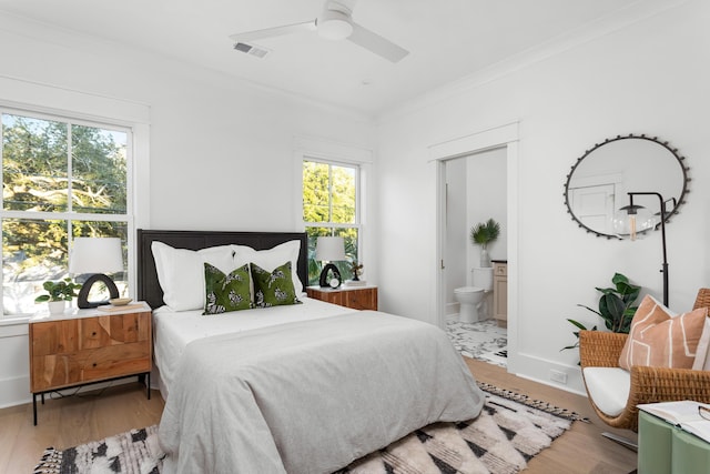 bedroom with ornamental molding, multiple windows, and light hardwood / wood-style flooring