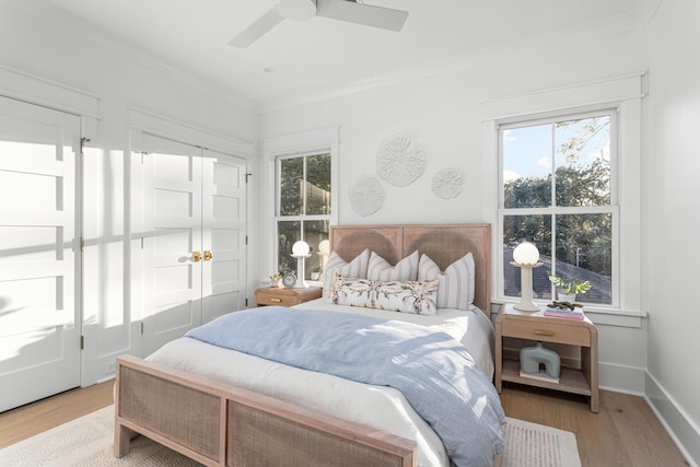 bedroom with ceiling fan, ornamental molding, and light hardwood / wood-style flooring