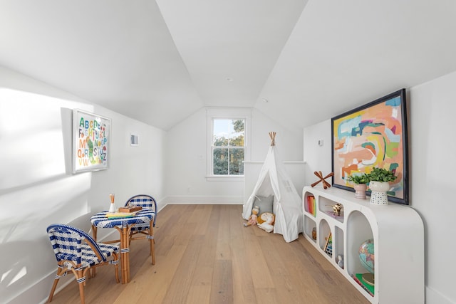 rec room featuring lofted ceiling and light hardwood / wood-style flooring