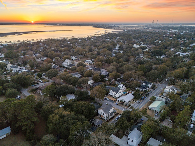 aerial view at dusk featuring a water view