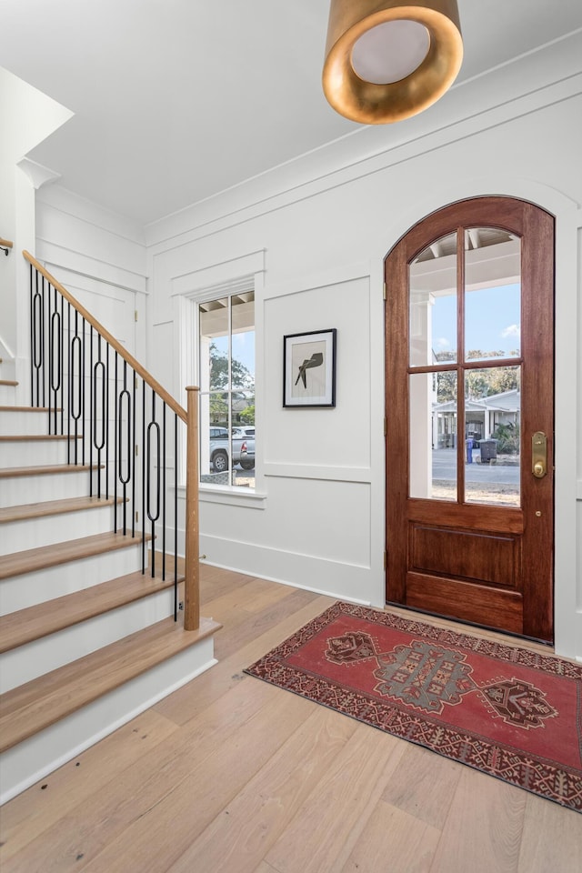 foyer entrance with wood-type flooring and a healthy amount of sunlight