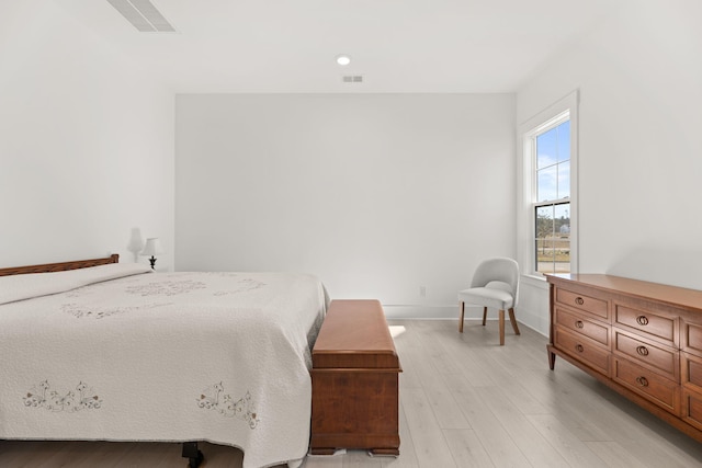 bedroom with visible vents, light wood-style flooring, and baseboards