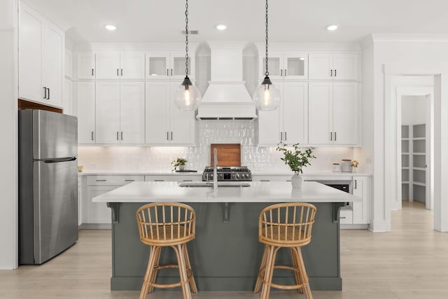 kitchen featuring freestanding refrigerator, light countertops, a sink, and custom exhaust hood