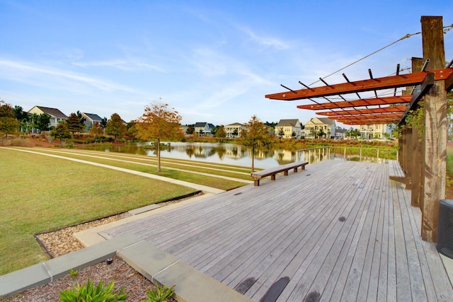 wooden deck featuring a water view, a lawn, and a pergola