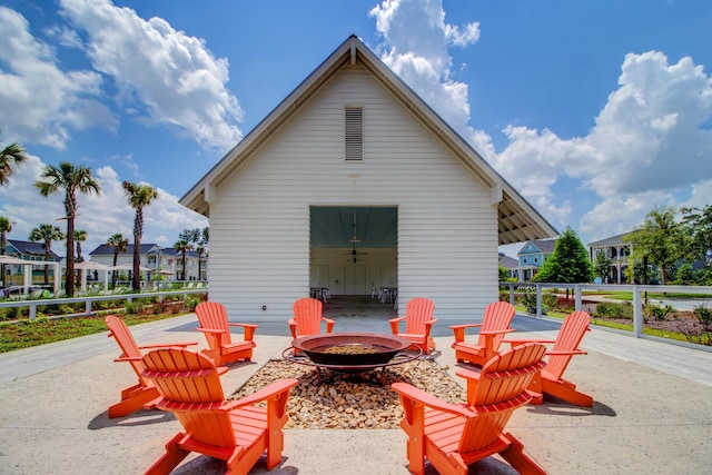 view of patio / terrace with a fire pit and an outdoor structure