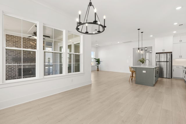 dining area with light wood-style floors, recessed lighting, baseboards, and ceiling fan with notable chandelier