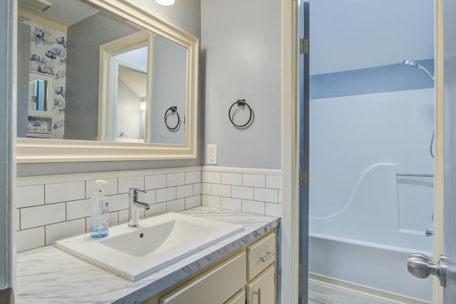 bathroom featuring shower / bath combination, vanity, and tasteful backsplash