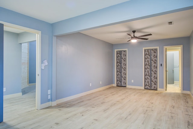 empty room with ceiling fan and light hardwood / wood-style floors