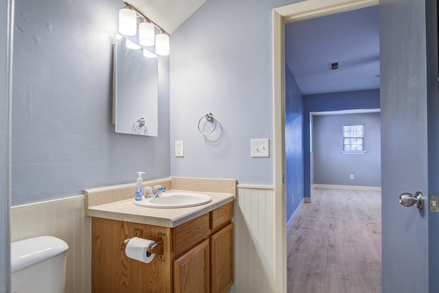 bathroom featuring vanity, hardwood / wood-style floors, and toilet