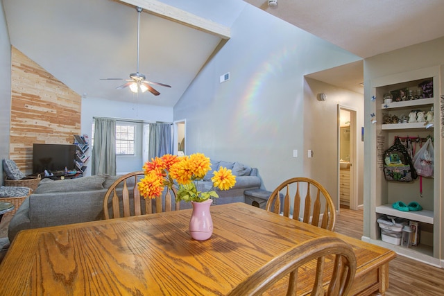 dining space featuring hardwood / wood-style flooring, built in features, high vaulted ceiling, and ceiling fan