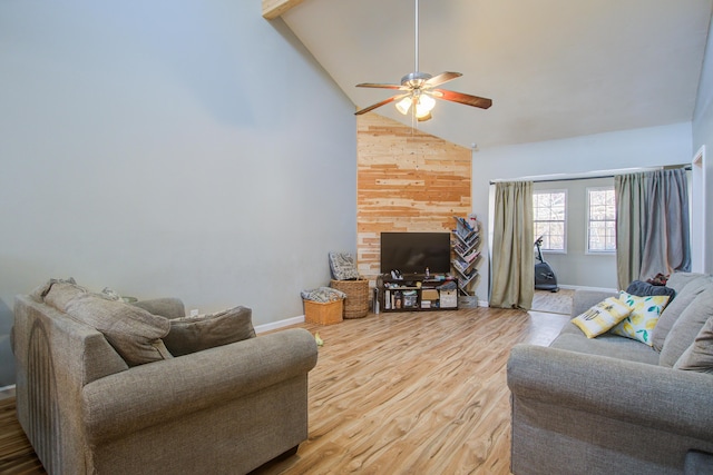 living room featuring hardwood / wood-style flooring, ceiling fan, high vaulted ceiling, and wood walls