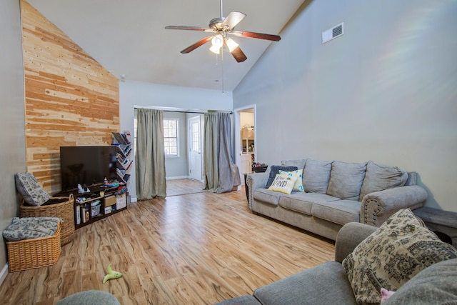 living room with ceiling fan, high vaulted ceiling, and light wood-type flooring