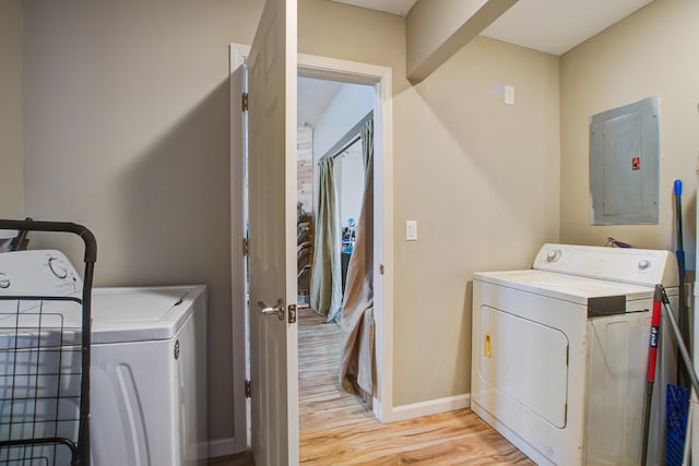 washroom featuring separate washer and dryer, electric panel, and light wood-type flooring