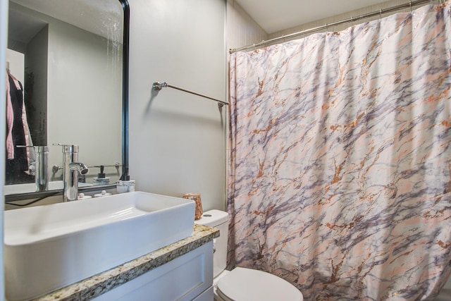 bathroom featuring vanity, curtained shower, and toilet