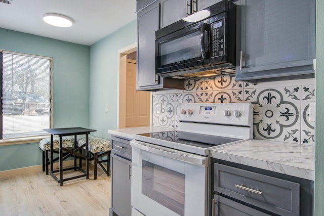 kitchen featuring backsplash, light hardwood / wood-style floors, and electric range