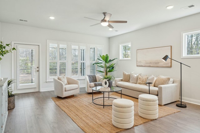 living area featuring recessed lighting, visible vents, and wood finished floors