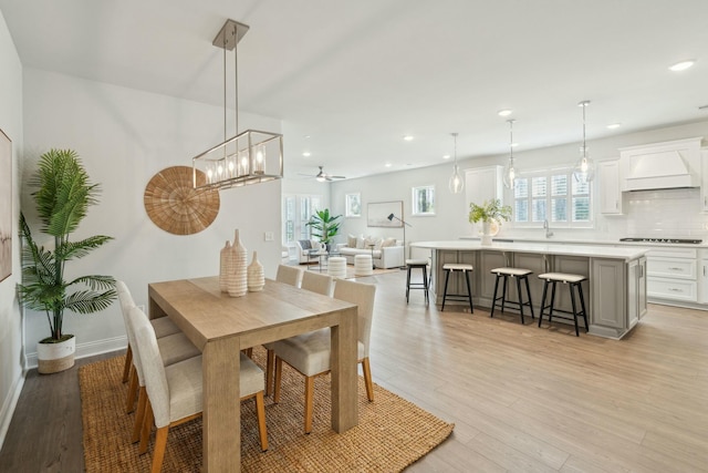 dining area with baseboards, light wood finished floors, a ceiling fan, and recessed lighting