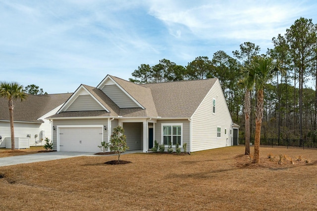 view of front of property with concrete driveway, a front lawn, an attached garage, and fence