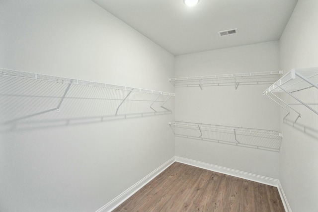 spacious closet featuring visible vents and dark wood finished floors