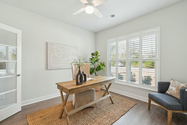 office space featuring dark wood-style floors, baseboards, visible vents, and a ceiling fan