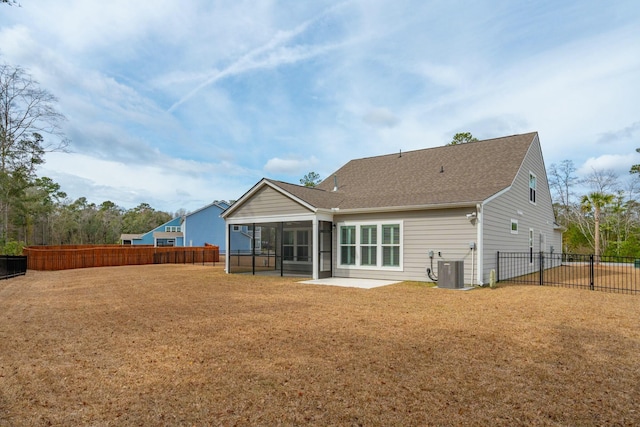 back of property with a sunroom, central AC, a yard, and fence