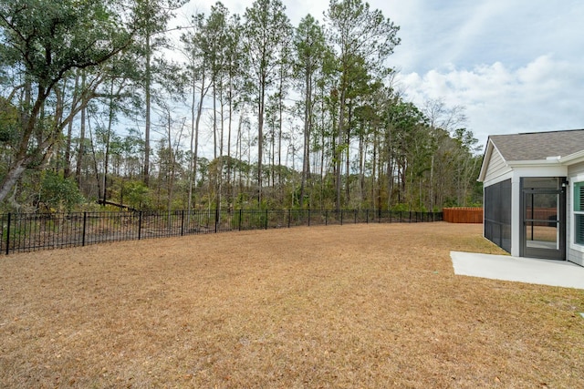 view of yard featuring a sunroom and a fenced backyard