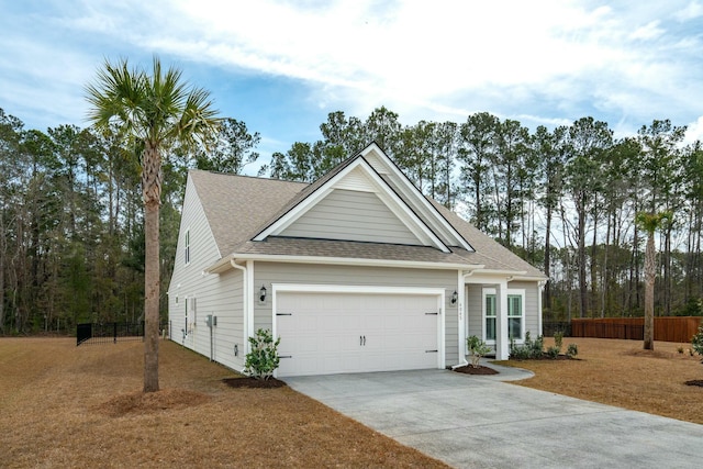 view of front of home featuring concrete driveway, roof with shingles, an attached garage, and fence