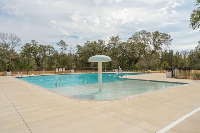 pool with a patio area and fence