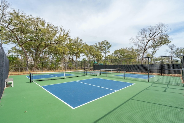 view of tennis court featuring fence