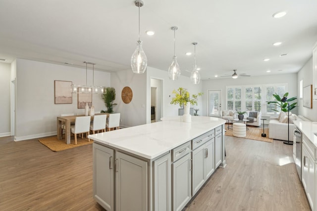 kitchen with a kitchen island, recessed lighting, gray cabinets, and light wood-style floors