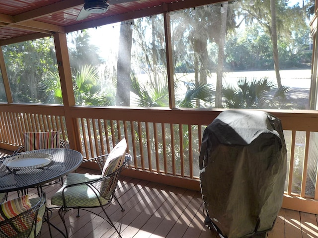 sunroom / solarium with ceiling fan, a water view, and a healthy amount of sunlight