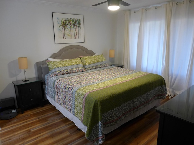 bedroom with ceiling fan, dark hardwood / wood-style flooring, and ornamental molding