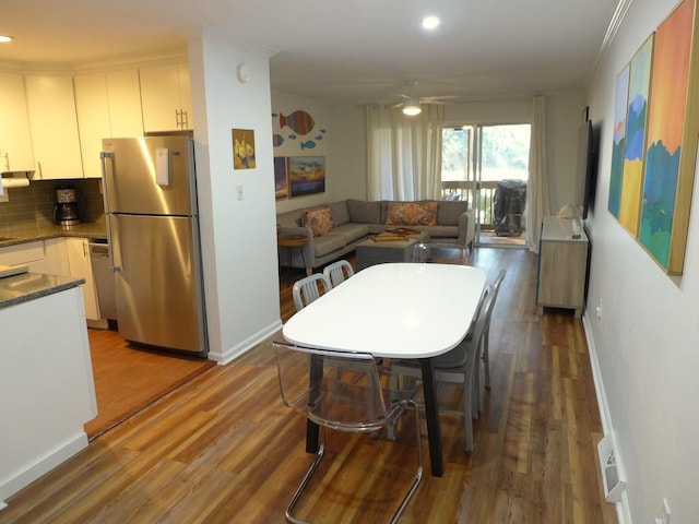 dining space with ceiling fan, dark hardwood / wood-style flooring, and crown molding