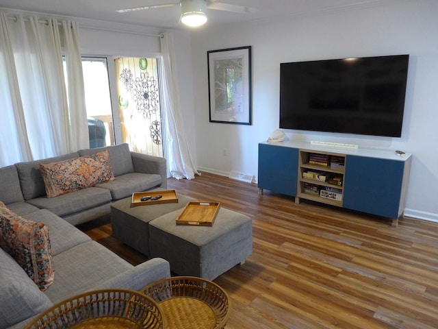 living room featuring ceiling fan, wood-type flooring, and ornamental molding