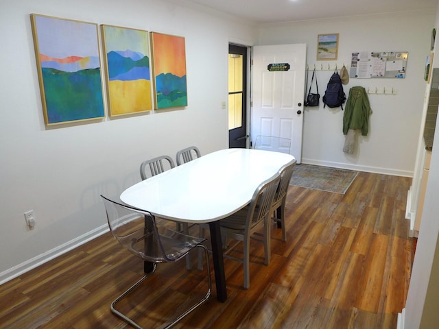 dining room with crown molding and dark hardwood / wood-style floors