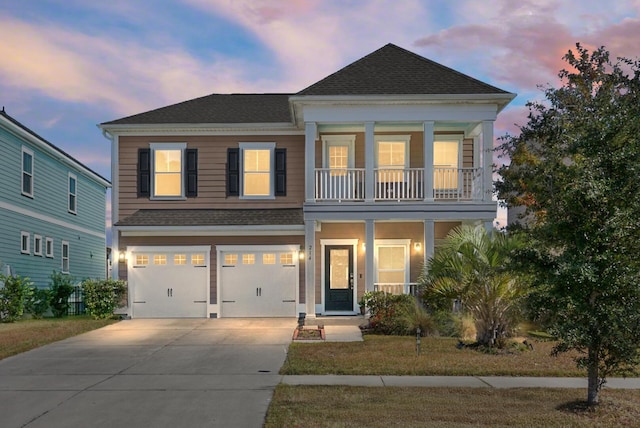 view of front of house with a yard, a balcony, and a garage