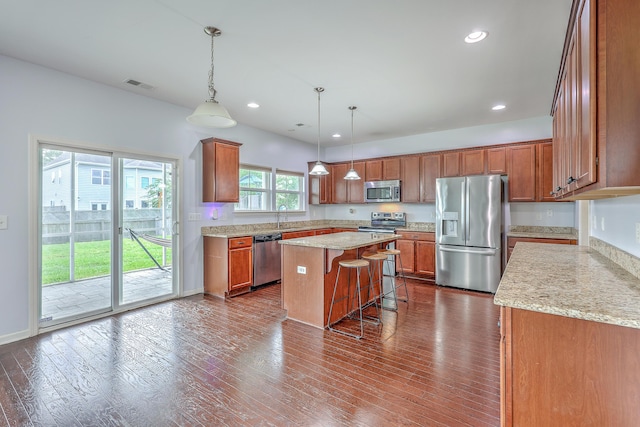 531 Crossland Dr, Moncks Corner, SC 29461 - kitchen featuring stainless steel appliances, a breakfast bar area, brown cabinetry, dark wood-type flooring, and recessed lighting
