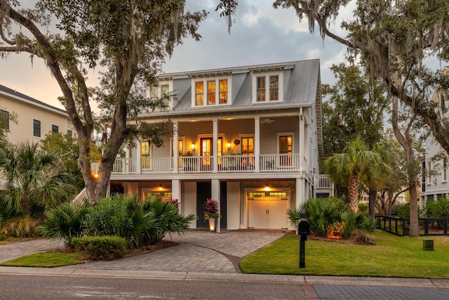 coastal inspired home with a garage and a yard